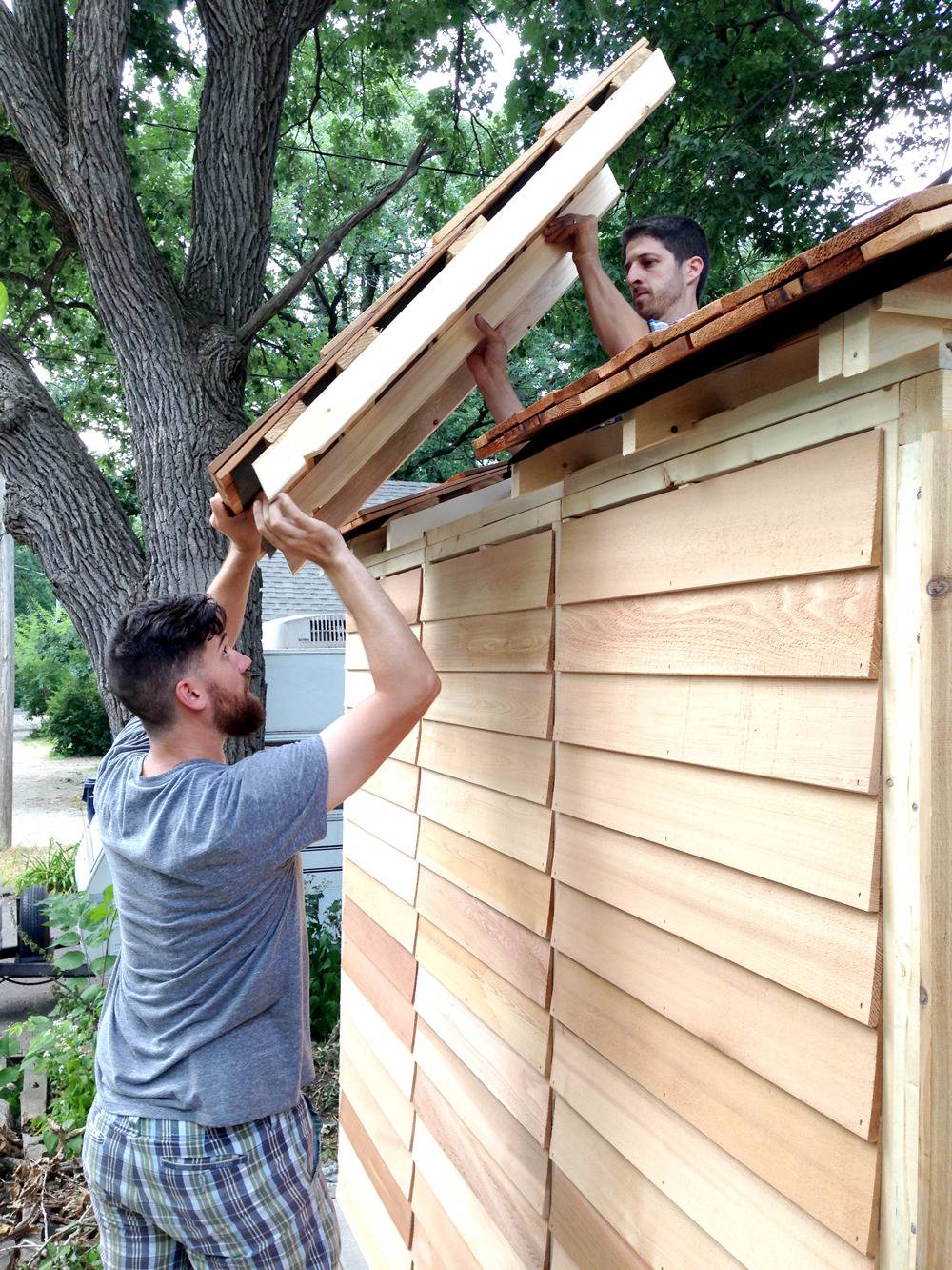 A wooden house that is being built outside in the daylight.
