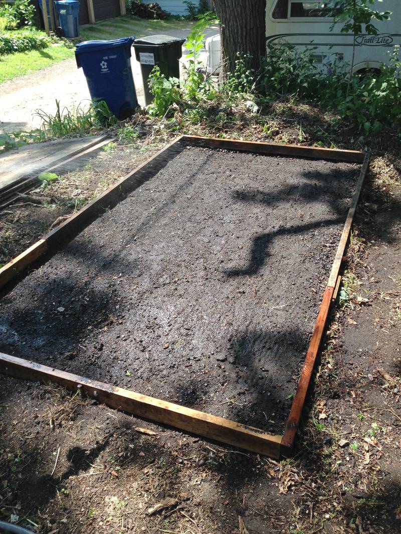 Wood slats in a rectangle hold poured concrete in place.