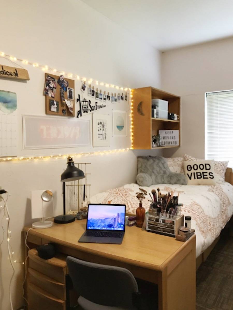 bed with table at the end that has a laptop on it