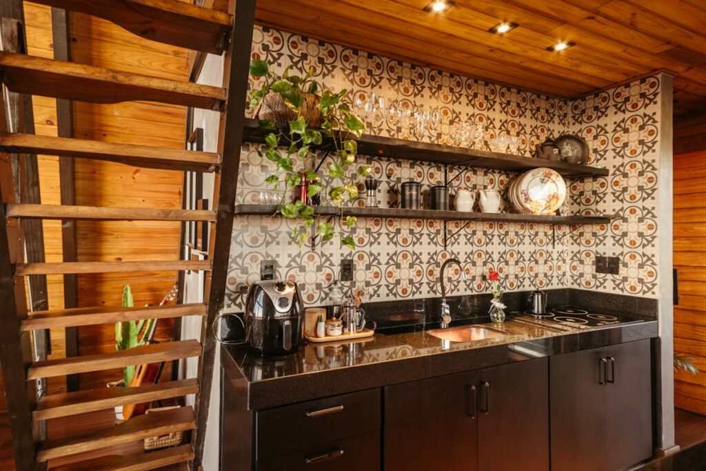 Charming kitchen with ornate tile backsplash, wooden shelves, and modern appliances.